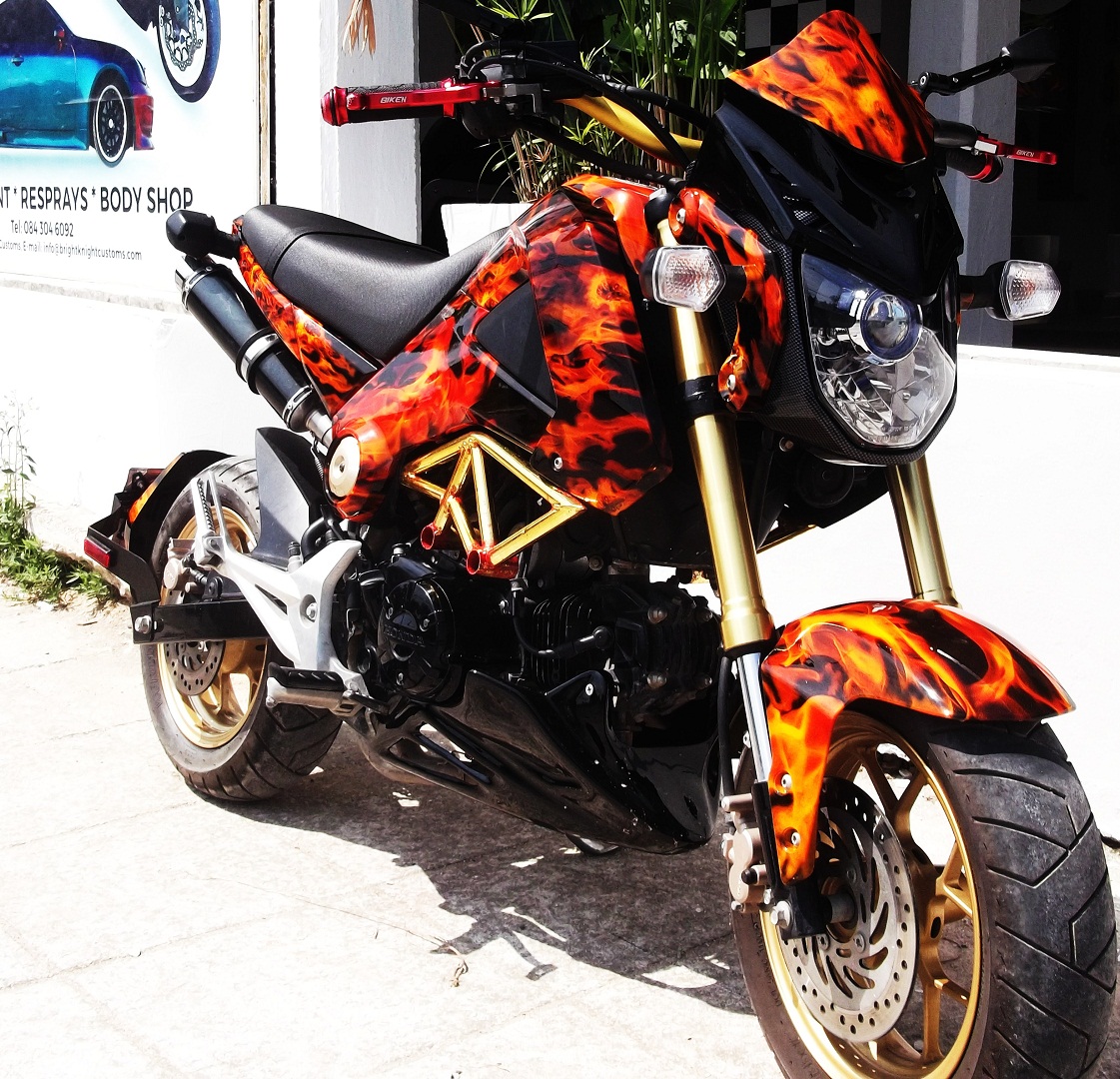 This is a Honda MSX 125 Grom, Hydro dipped in true flames with mini skulls. Has some after market upgrades too, dual exhaust, bottom scoop and top fairing.