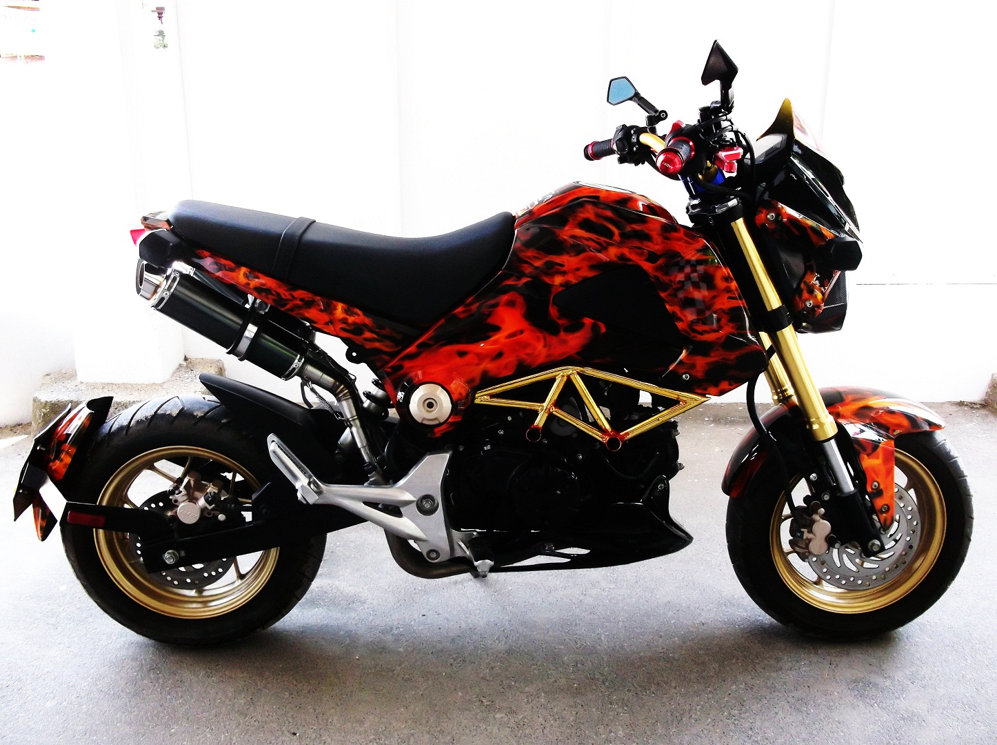 This is a Honda MSX 125 Grom, Hydro dipped in true flames with mini skulls. Has some after market upgrades too, dual exhaust, bottom scoop and top fairing.